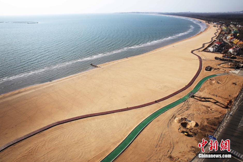 3月13日，秦皇島萬(wàn)米臨海沙灘木棧道。據(jù)了解，該木棧道全長(zhǎng)約4200米，與北戴河區(qū)原有的7500米木棧道對(duì)接后全線總長(zhǎng)度1.17萬(wàn)米，整個(gè)木棧道東起秦皇島體育基地游船碼頭，西至北戴河濕地公園，呈波浪形蜿蜒10.4公里海岸線。 中新社發(fā) 曹建雄 攝 CNSPHOTO